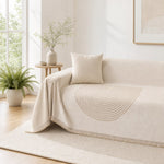 Arch lines couch cover in cream draped over a couch, tan arch medallion and brush fringe