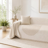 Arch lines couch cover in cream draped over a couch, tan arch medallion and brush fringe