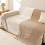 The warm tan reverse face of the arch lines cover styled on a couch