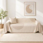 Cream arch lines couch cover styled on a loveseat in a bright living room