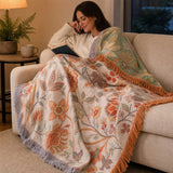 Woman reading on the sofa under the floral throw at dusk