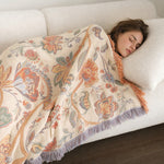 Woman asleep on the sofa under the boho floral blanket