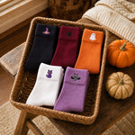 Five Halloween sock pairs in a basket