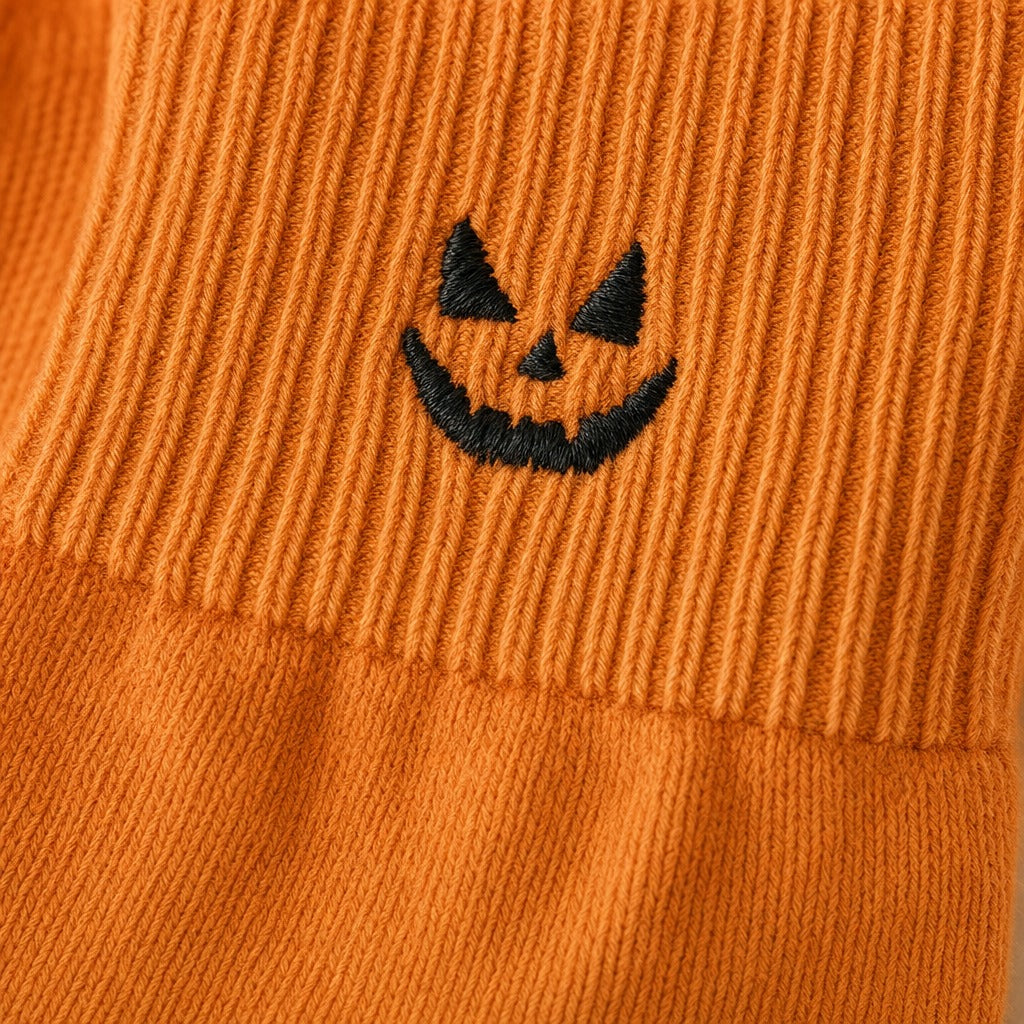 Macro of the embroidered pumpkin and ribbed cuff seam
