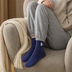 Navy ghost Halloween socks worn at home on an armchair