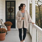 Woman in the oatmeal cardigan and black leggings on an autumn front porch :: The model is 5'5" and wears a size M