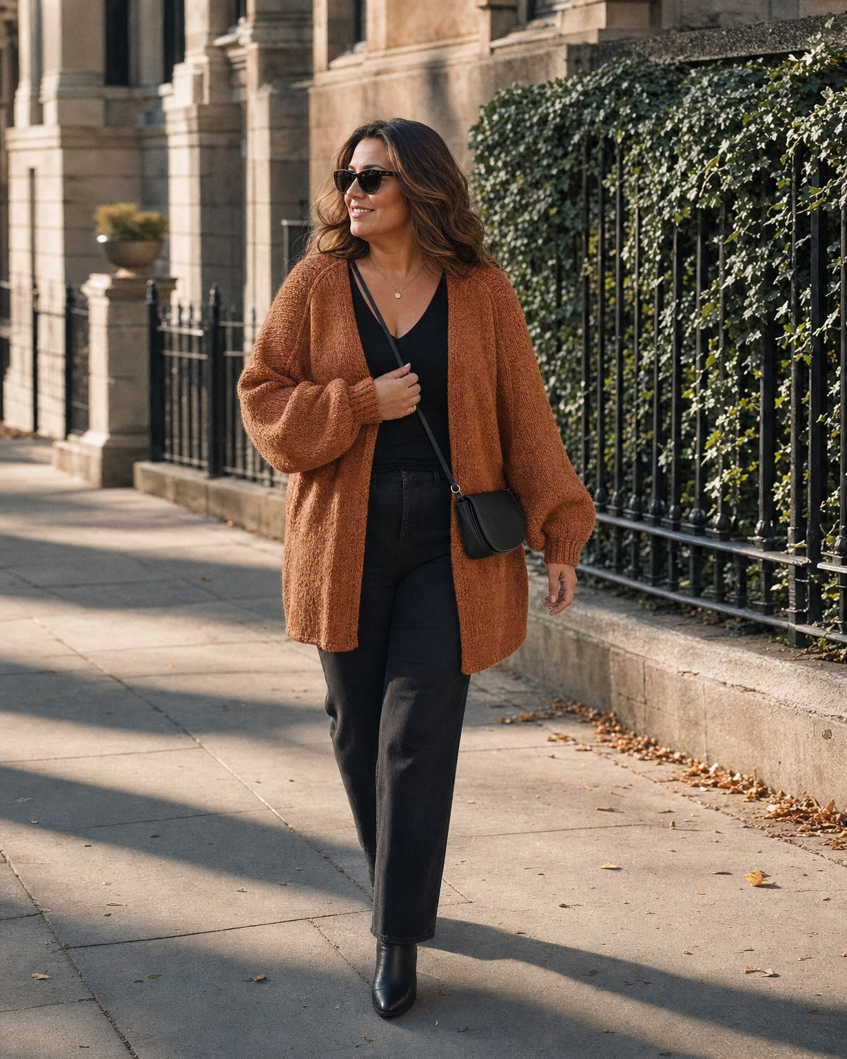 Curvy woman wearing the rust cardigan in size XL on a city sidewalk :: The model is 5'8" and wears a size XL