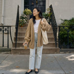 Petite woman wearing the camel cardigan in size S on brownstone steps :: The model is 5'2" and wears a size S