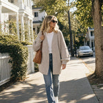 Woman wearing the oatmeal cardigan with a white tee and jeans on a tree-lined street :: The model is 5'7" and wears a size M